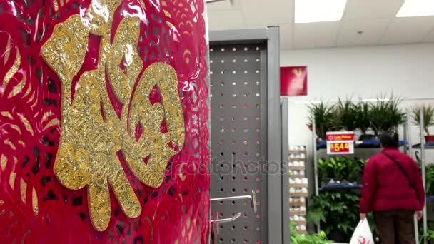 One side of selling Chinese New Year scroll display and shopper walking through inside Walmart store — Stock Video