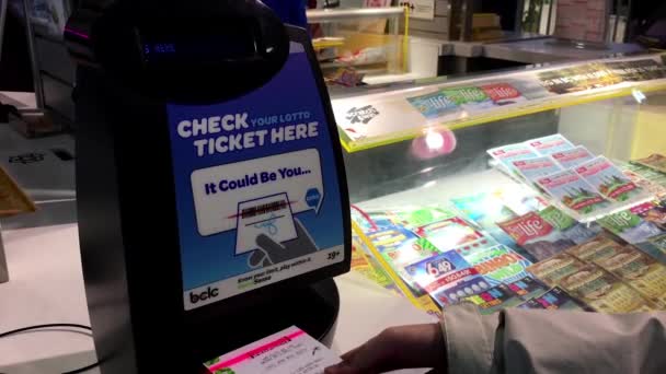 Крупним планом жінка перевірка лотерейний квиток всередині торговий центр — стокове відео