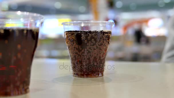Twee kopjes van coca cola op tafel binnen shopping mall — Stockvideo