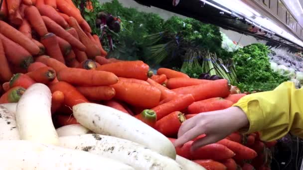 Pohyb lidí, výběr mrkev uvnitř supermarketu T & T — Stock video