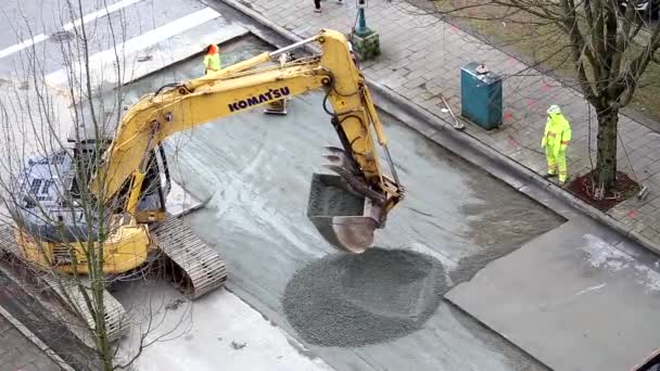 Escavadora de construção levando asfalto para frente e para trás na estrada — Vídeo de Stock