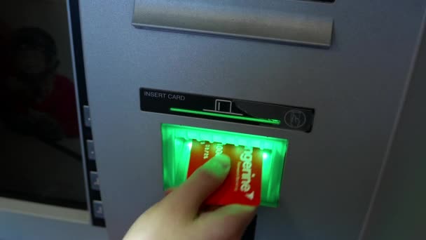 Женщина снимает деньги и вставляет банковскую карту в банкомат — стоковое видео