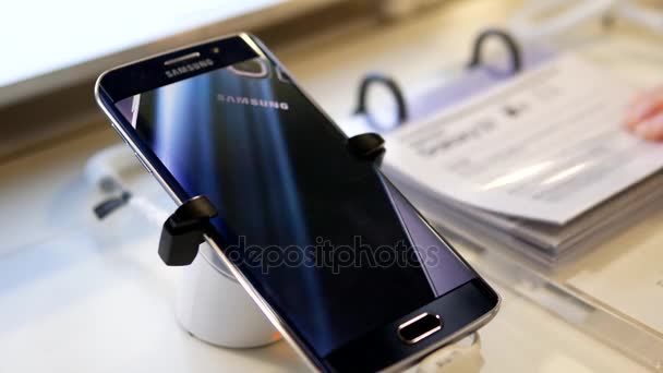 Mensen op zoek prijskaartje met display Samsung Galaxy Note 7 cellphone hoogstens kopen winkel — Stockvideo