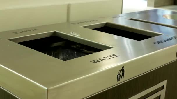 Woman throwing trash to the garbage can inside shopping mall — Stock Video