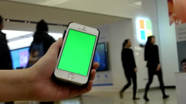 Mujer sostiene un dispositivo inteligente en blanco con una pantalla verde para su propio contenido personalizado frente a la tienda de Microsoft en Burnaby BC Canada . — Vídeo de stock