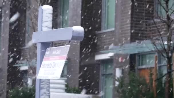 Apartment for sale sign in front of new buiding cold blizzard snow winter day — Stock Video