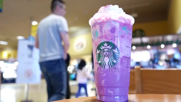 Binnenkant Starbucks opslaan met gelimiteerde unicorn frappuccino gemengd drankje op tafel — Stockvideo