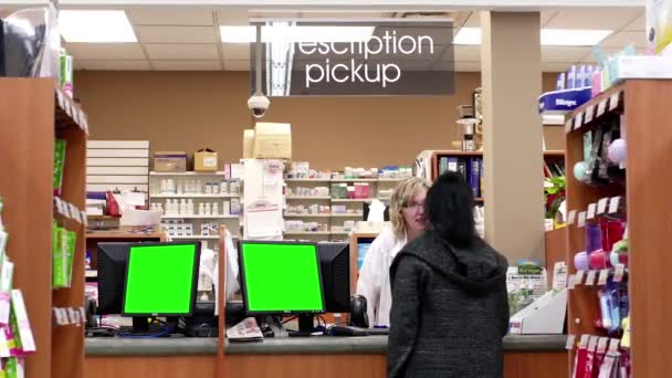 De monitor van de mensen oppakken van haar voorschriftgeneeskunde met groen scherm bij apotheek sectie in Port Coquitlam Bc Canada. — Stockvideo