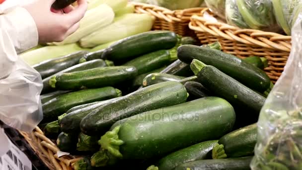 Motie van vrouw zocchini squash selecteren in supermarkt produceren departement — Stockvideo