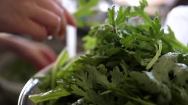 Ağır çekim evye Çin sebze yıkama ve bir kevgir içinde koyarak kadın