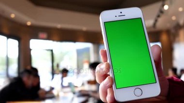 Yeşil ekran tutup telefon Starbucks mağaza içinde tıklatarak el 