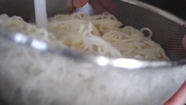 Slow motion of woman draining cooked noodles — Stock Video