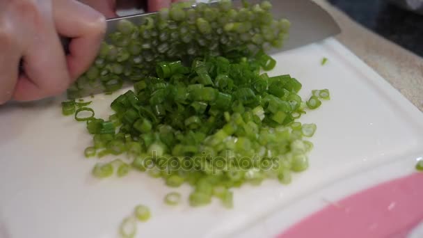 Movimiento lento de la mujer cortando cebolla verde en la tabla de cortar — Vídeos de Stock