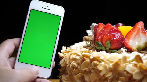 运动的水果生日蛋糕和黑色背景上的手绿屏电话 — 图库视频影像