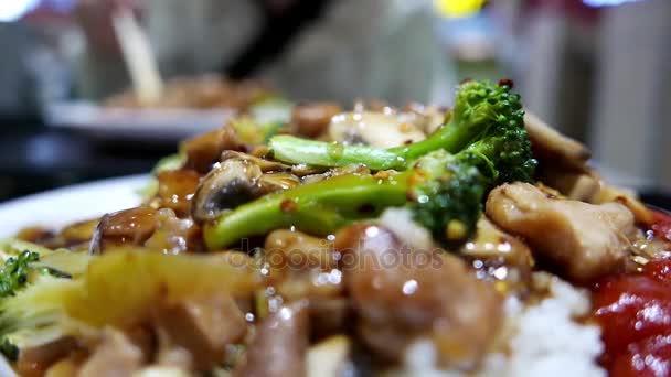 Движение людей, которые едят жареную курицу и рис в зоне фуд-корта — стоковое видео