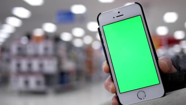 Donna in possesso di schermo verde telefono cellulare su sfondo bella illuminazione sfocata — Video Stock