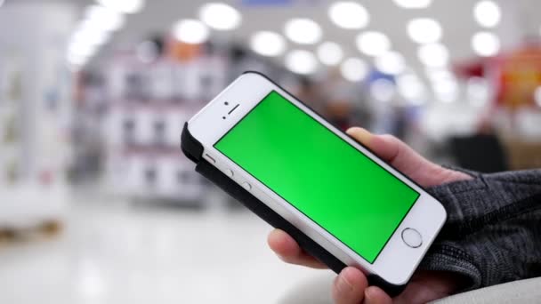 Woman holding green screen mobile phone on beautiful blurred lighting background — Stock Video