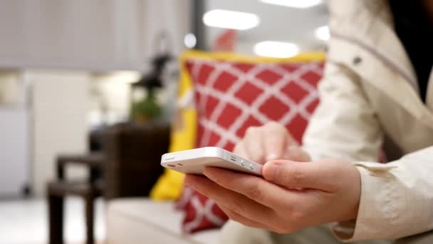 Kvinna med sin mobiltelefon på soffa med bokeh shopping koncept — Stockvideo