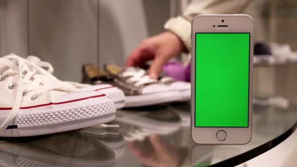 Movimiento de la mujer que compra zapatos y teléfono de pantalla verde — Vídeos de Stock