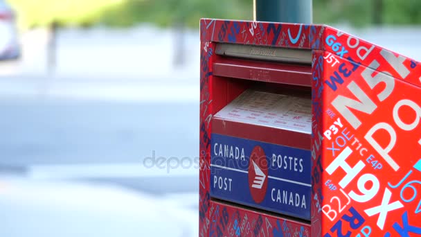 Movimiento de la mujer que coloca el correo en un buzón canadiense con fondo de flujo de tráfico borroso — Vídeo de stock