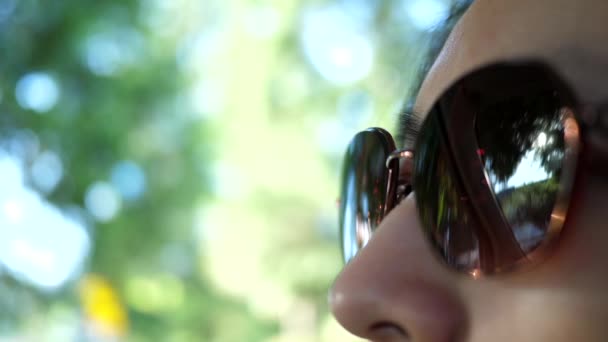 Motion of woman wears sunglasses eyes looking on road with blur traffic flow — Stock Video