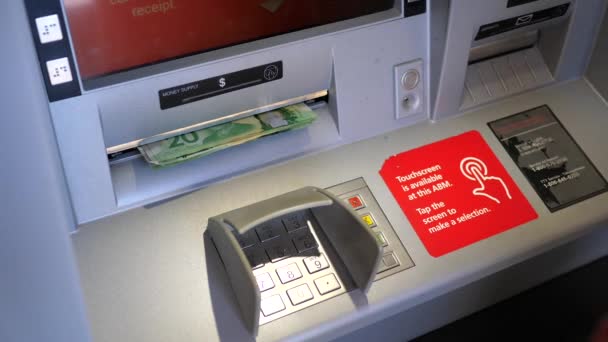 Femme retirant de l'argent à la machine ATM  