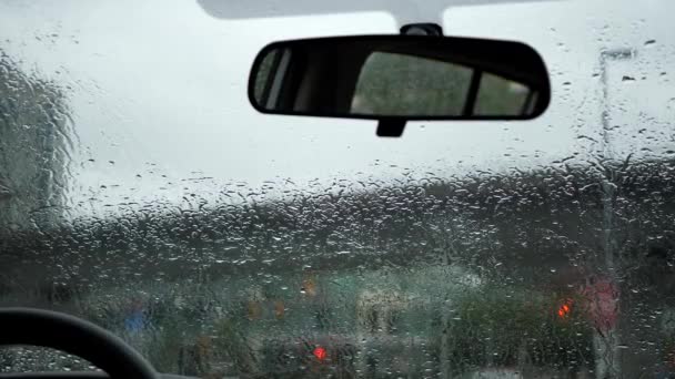 Motie van de weergave van de regenachtige dag tijdens auto voorruit ruitenwissers regen druppels glijden neer in een auto — Stockvideo