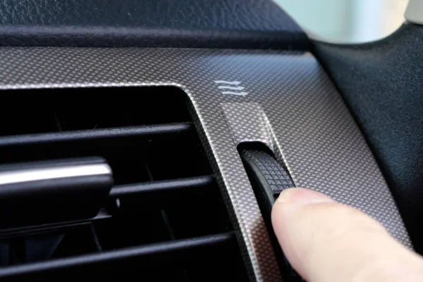 A woman's hand adjusts the vent on car dashboard — Stock Photo, Image