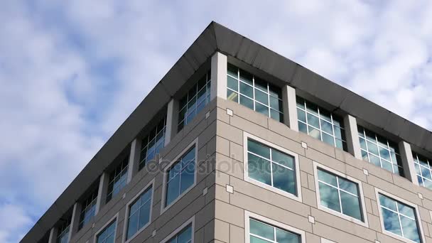 Movimiento del cielo nublado con fachada de vidrio reflejado iluminado en el moderno edificio de oficinas — Vídeos de Stock