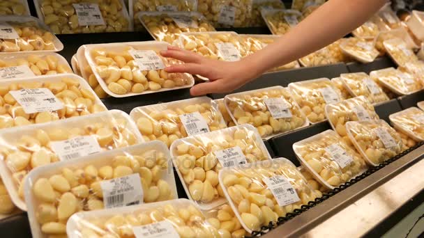 Motion of woman's hand picking garlic inside superstore — Stock Video