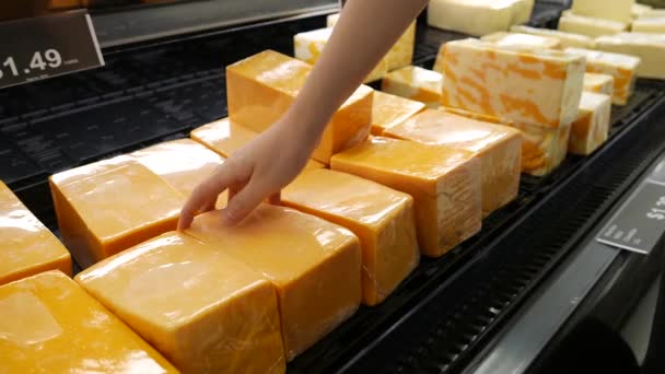 Рух жіночої руки збирання сиру всередині супермаркету — стокове відео