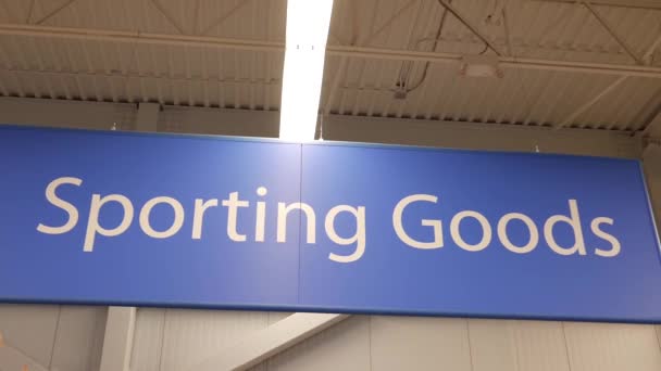 Motion of sporting good sign on sport equipment section inside Walmart store — Stock Video