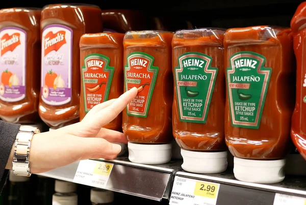 Close up woman buying Heniz ketchup hot pepper sauce inside buy low foods store — Stock Photo, Image