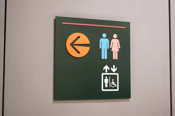 Fechar o homem, mulher e desativar o logotipo banheiro na parede — Fotografia de Stock