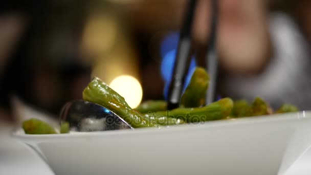 Vervagen van de beweging van vrouw green bean eten op tafel binnen Chinees restaurant — Stockvideo