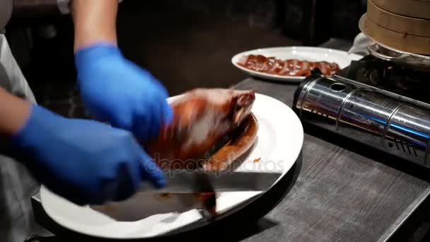 Motion du chef coupant canard rôti dans une assiette pour le client — Video