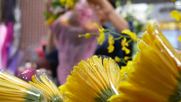 Çiçekçi bulanıklık hareket bir buket çiçek müşteri için hazırlar — Stok video
