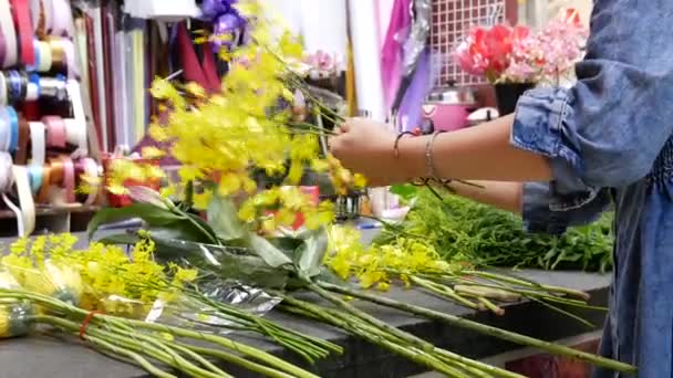 Motie van de bloemist bereidt een boeket bloemen voor klant — Stockvideo