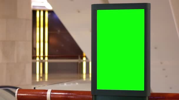Mouvement du grand panneau d'affichage d'écran vert à côté de l'escalator à l'intérieur du centre commercial 