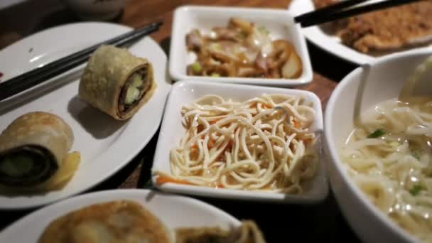 El lapso de tiempo de la gente comiendo comida en la mesa dentro del restaurante chino — Vídeos de Stock