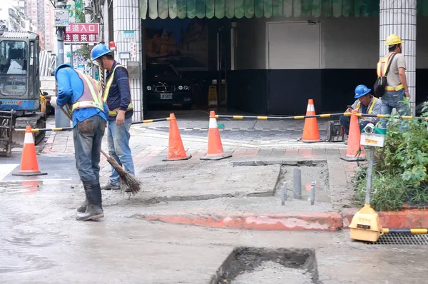 Movimento do trabalhador e escavadeira de construção levando asfalto para frente e para trás na estrada — Fotografia de Stock