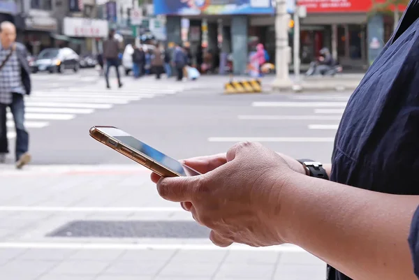 Ruchu kobiety przekraczania ulicy i przy użyciu telefonu komórkowego w Tajpej na Tajwanie — Zdjęcie stockowe