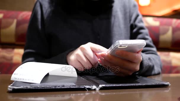 在中餐厅用餐后使用手机计算小费的妇女的运动 — 图库视频影像