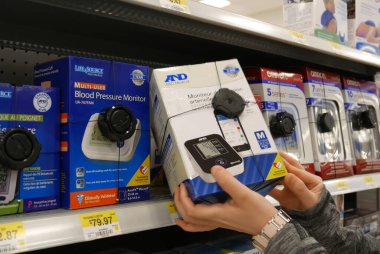 Coquitlam, BC, Kanada - 22 Temmuz 2016: Walmart mağazasından A & D kan basıncı monitörü alan kadın