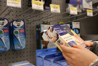 Coquitlam, BC, Kanada - 22 Temmuz 2016: Walmart mağazasında oksijen darbesi oksimetresi alan kadın