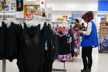Coquitlam, BC, Kanada - 22 Temmuz 2016: Walmart mağazasında satılan giysiler için fiyat etiketini kontrol eden işçiler