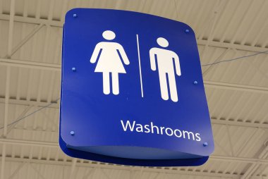 Çatıda asılı duran kadın ve erkeğin banyo logosu.