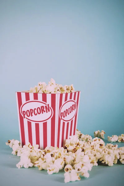 Plechovka popcorn na modrém pozadí Vintage Retro filtru. — Stock fotografie