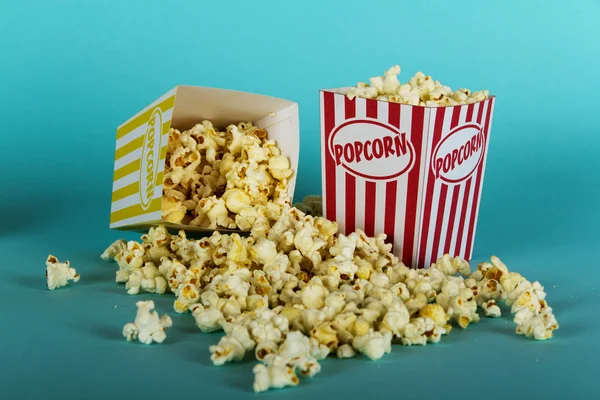 Plechovka popcorn na modrém pozadí — Stock fotografie