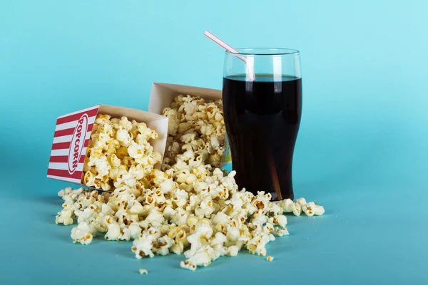 Plechovka popcorn na modrém pozadí — Stock fotografie